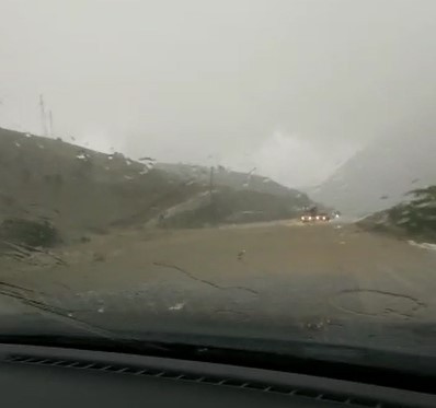 Rizeli sürücü yolun üzerinden akan dereye ve aralıksız yağan doluya rağmen yoluna böyle devam etti